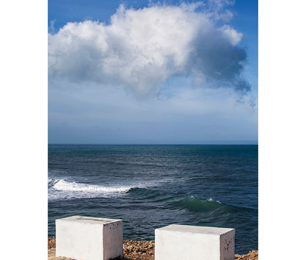 Nube sobre pilones de cemento con el mar y el cielo de fondo